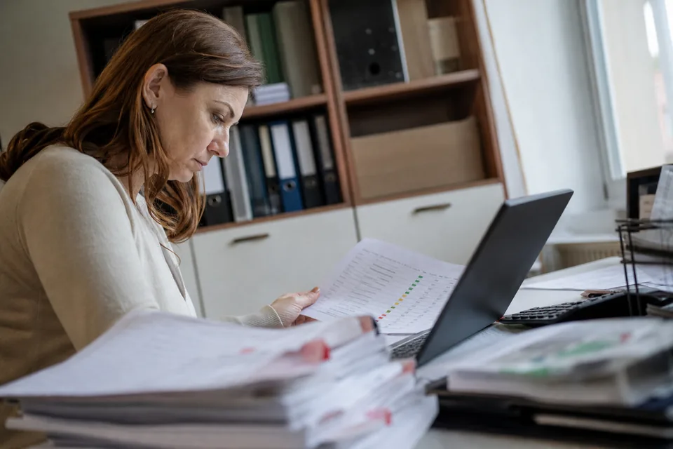 Kontrolerka finansowa przegląda listę odbiorców z oznaczonym poziomem ryzyka przy laptopie